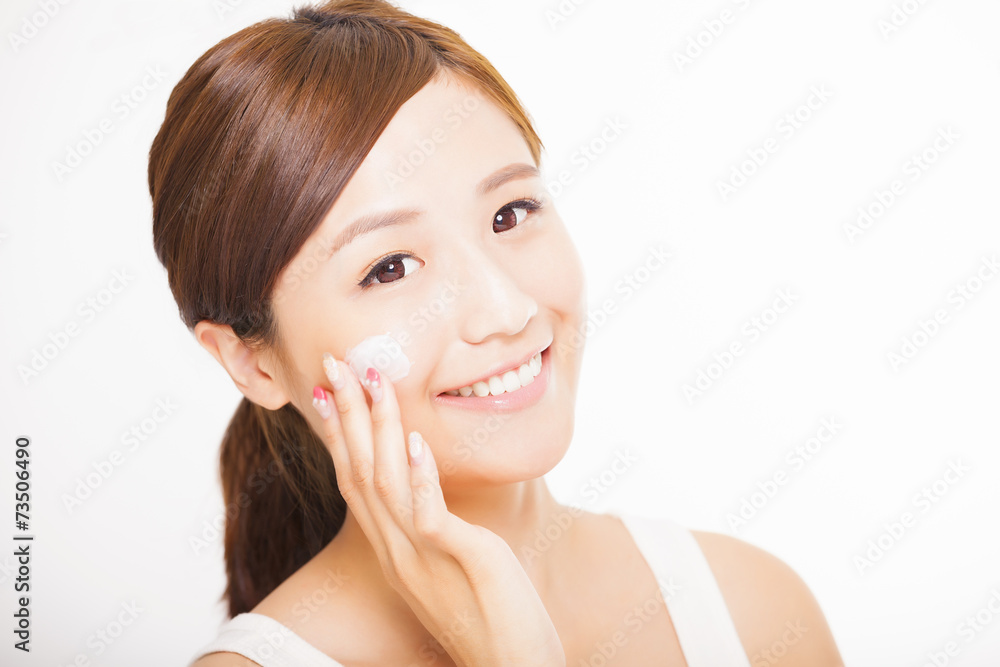 beautiful young woman applying cosmetic cream on her face beautiful young woman applying cosmetic cream on her face