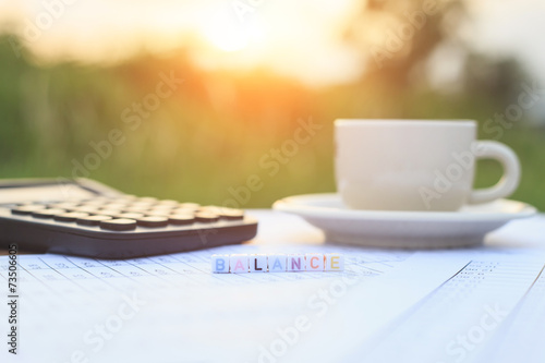 Balance written in letter beads and a coffee cup on table