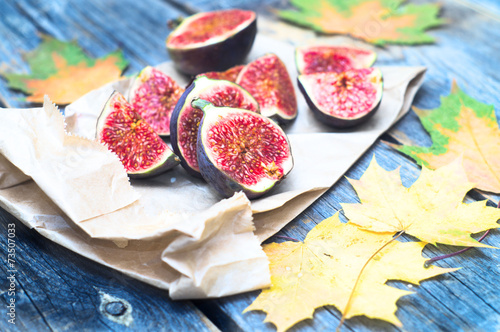 Figs and automn yellow leaves on the wooden rustic surface