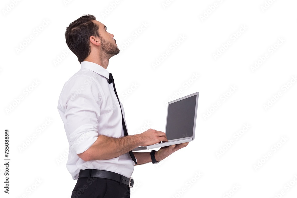 Sophisticated businessman standing using a laptop Sophisticated businessman standing using a laptop