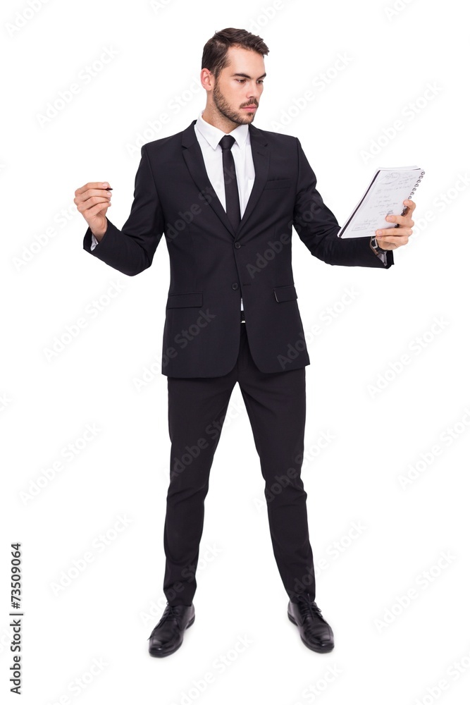 Focused businessman holding pen and notebook Focused businessman holding pen and notebook