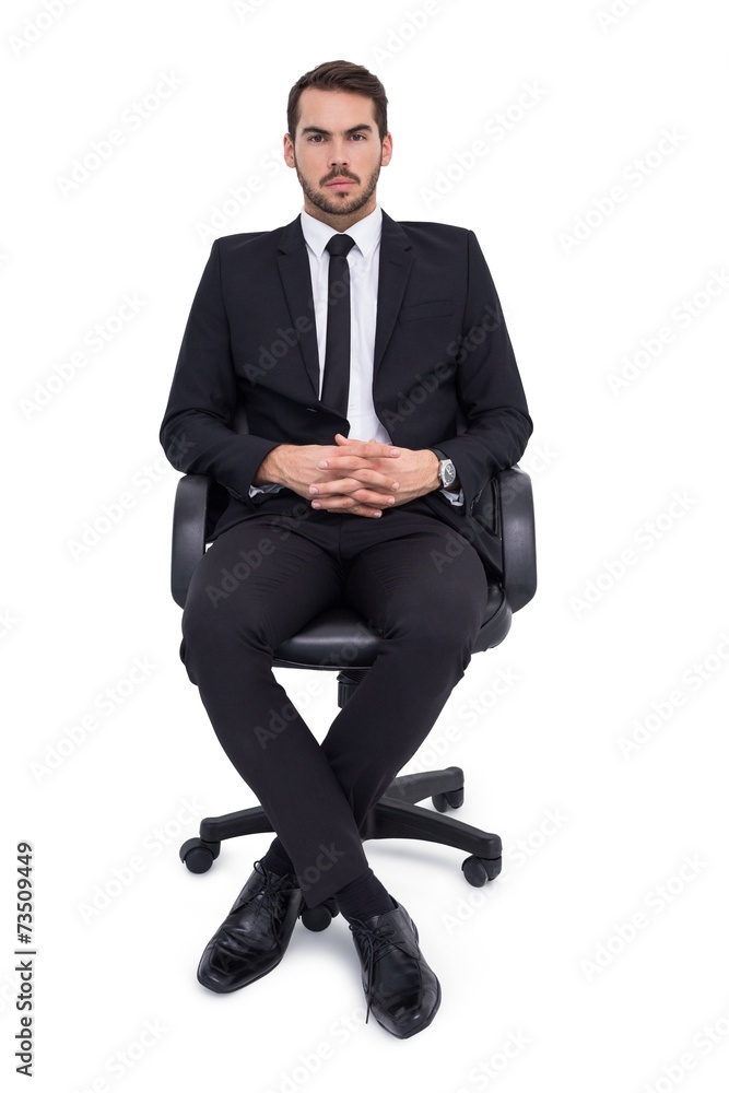 Stern businessman sitting on an office chair Stern businessman sitting on an office chair