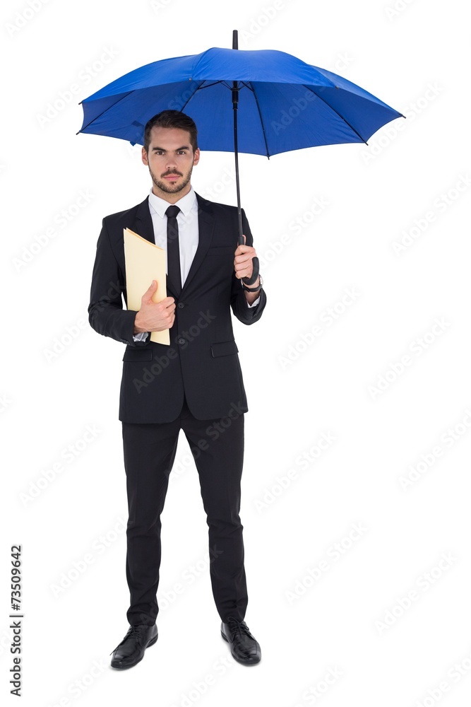 Serious businessman holding a file under umbrella Serious businessman holding a file under umbrella