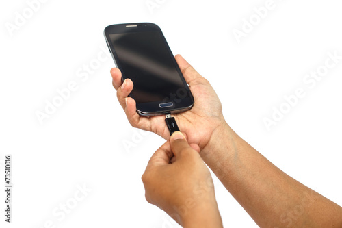 Hand holding smartphone and connect charger isolated on white ba photo