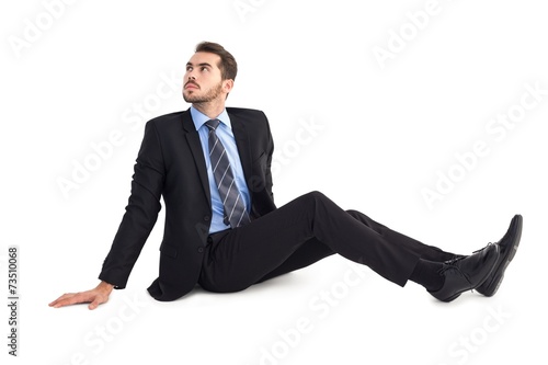 Businessman sitting on floor looking up