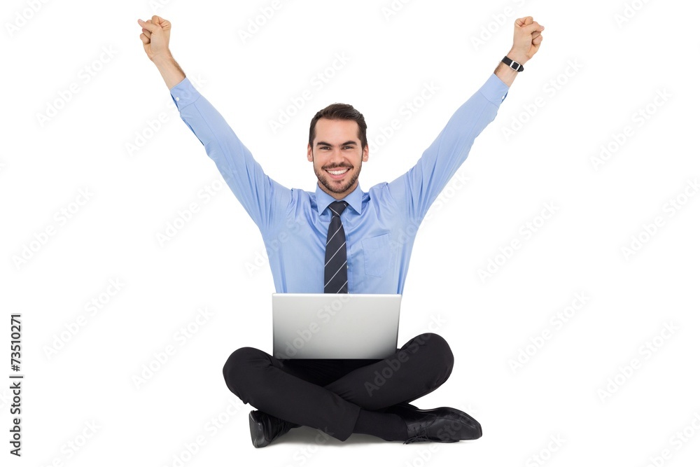 Smiling businessman sitting on the floor cheering Smiling businessman sitting on the floor cheering