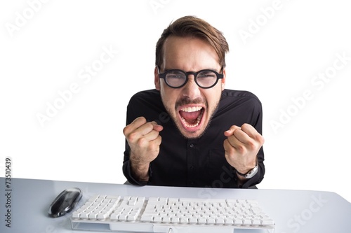 Businessman cheering in front of his computer