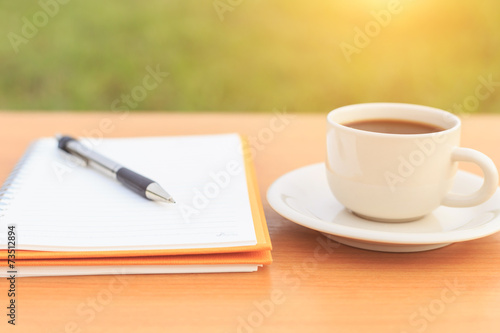 Close up coffee cup and notebook on the table