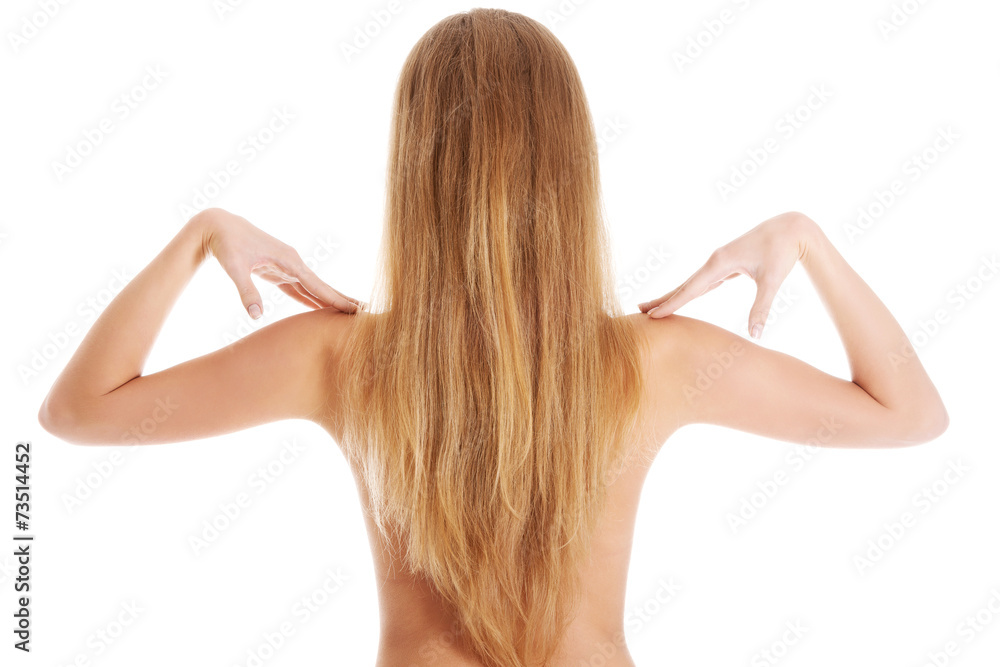 Naklejka premium Back view of nude woman touching her shoulders