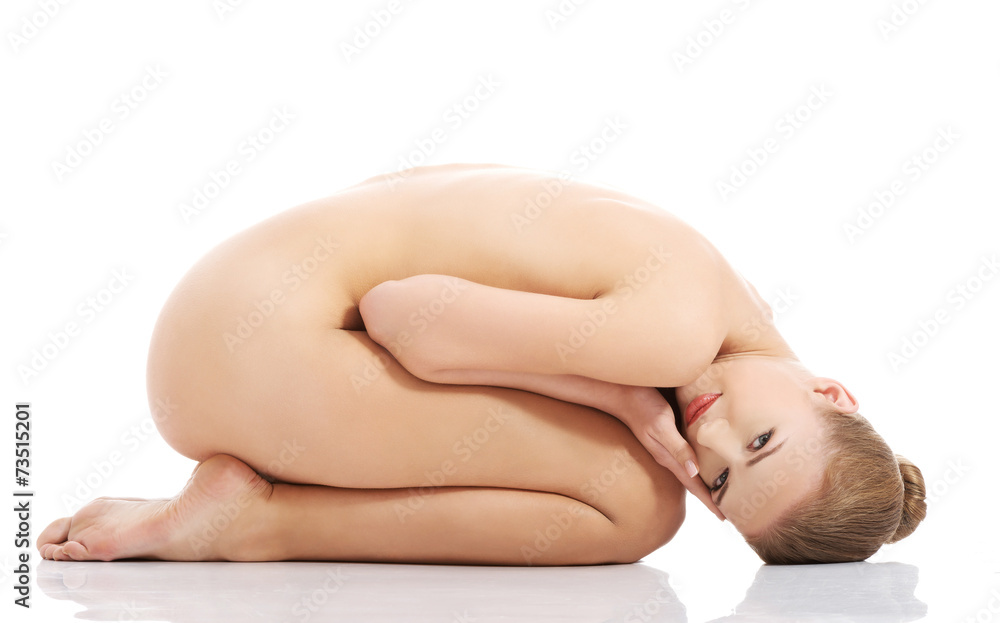Naklejka premium Side view nude woman curled up on the floor