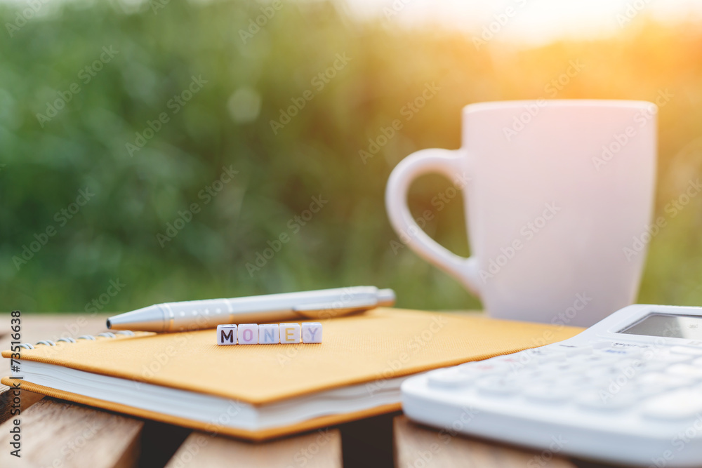 Money written in letter beads and a coffee cup on table Money written in letter beads and a coffee cup on table