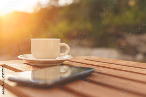 A cup of coffee and smartphone on the table