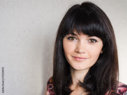 Portrait of young cheerful smiling woman, over grey background