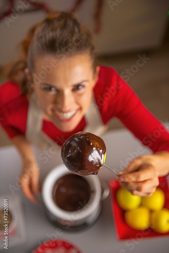 Closeup on housewife showing homemade apple in chocolate glaze
