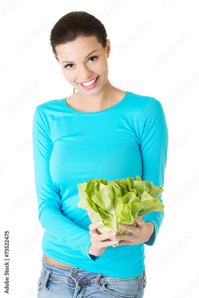 Happy young woman holding lettuce
