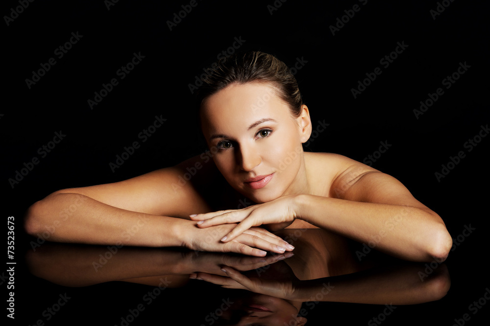 Fototapeta premium Nude blonde woman posing with arms on desk