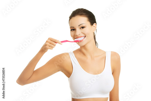 Young happy woman brushing her teeth