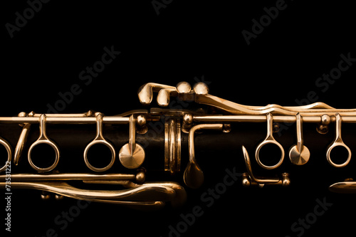 Fotografiet Detail of the clarinet in golden tones on a black background