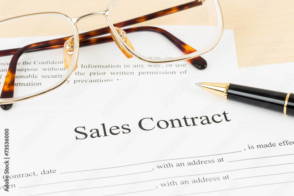 Sales contract document with glasses and pen Sales contract document with glasses and pen
