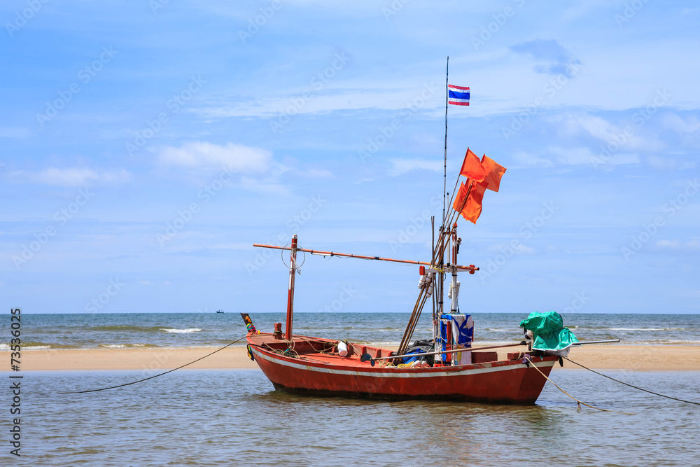 Obraz premium Traditional fishing boat on beach and blue sky