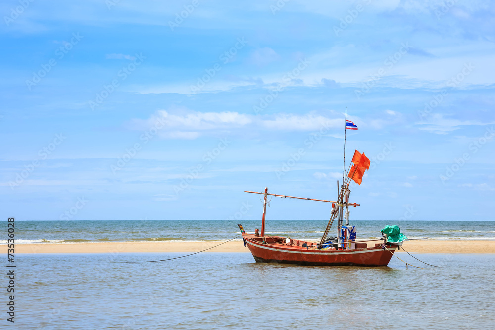 Traditional fishing boat on beach and blue sky
