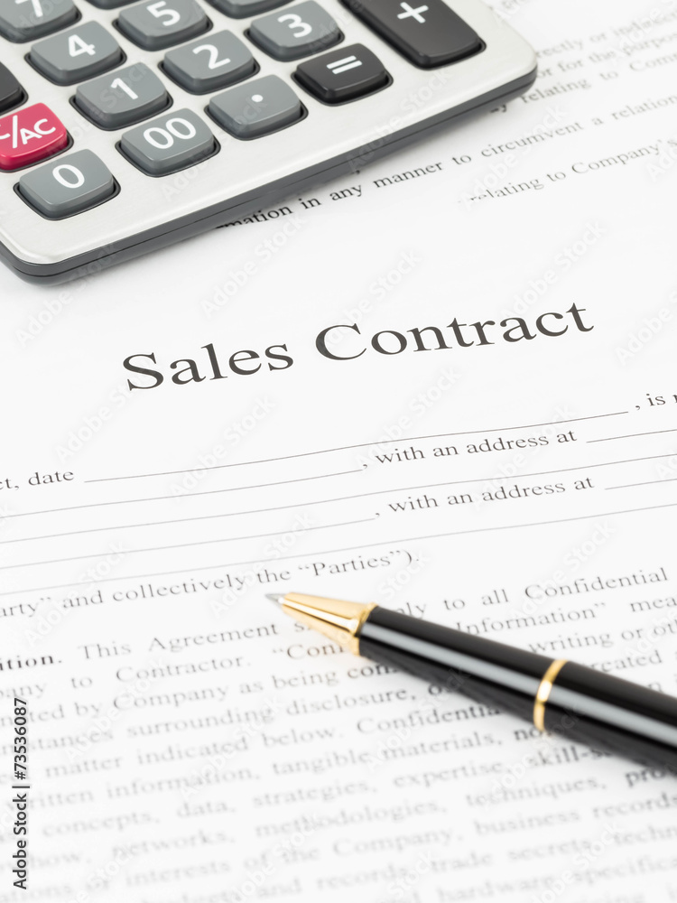 Sales contract document with calculator and pen Sales contract document with calculator and pen