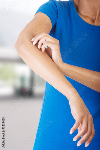 Young woman scratching her self.