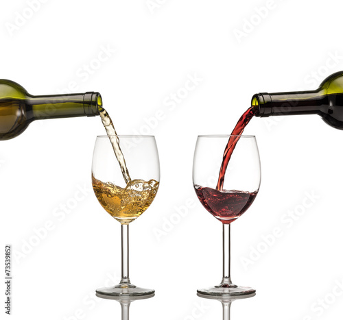 Red and white wine being poured into wine glass on white backgro