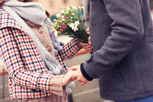 Billede på lærred Midsection of a couple holding hands and flowers