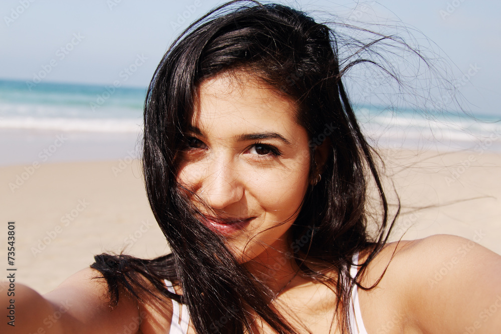 Beautiful girl smiling on the beach with the sand, sea and blue Beautiful girl smiling on the beach with the sand, sea and blue