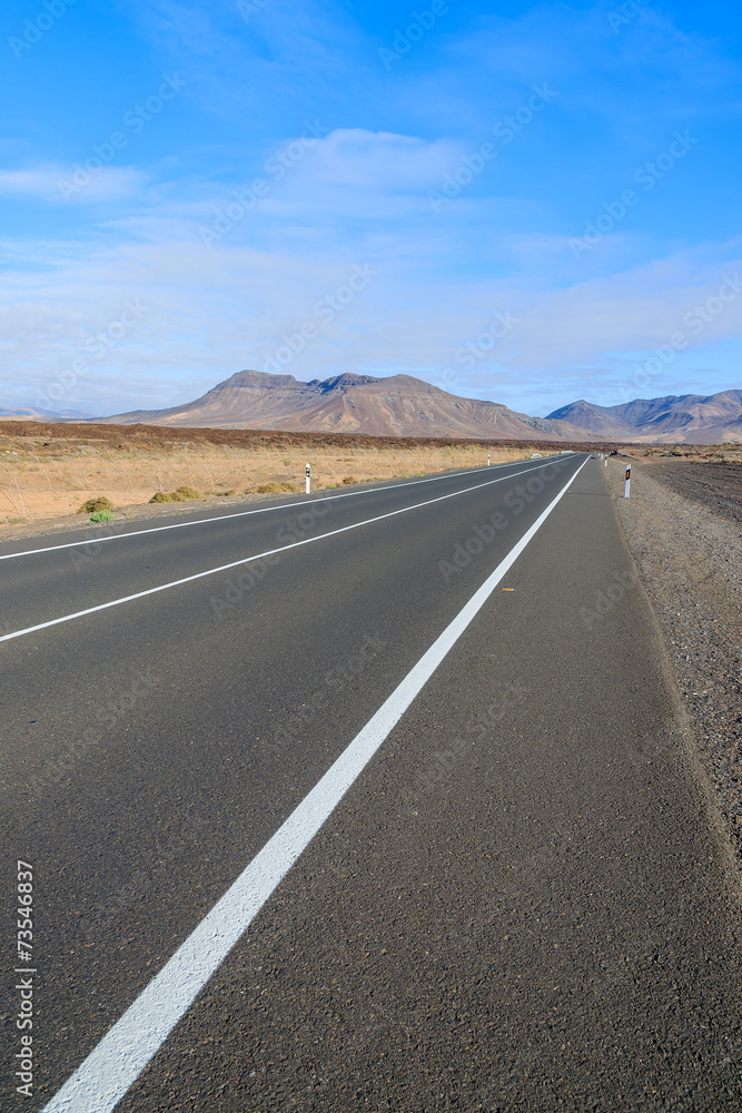Road in desert landscape with mountains, Fuerteventura island Road in desert landscape with mountains, Fuerteventura island