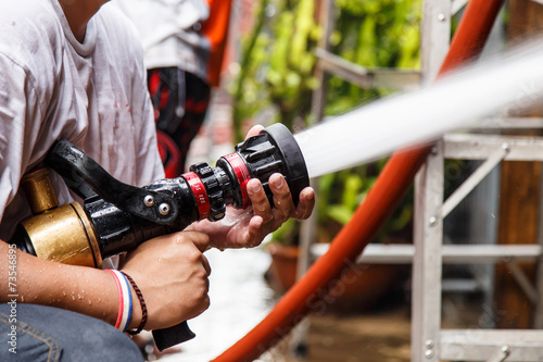 Fireman using water hose to prevent fire