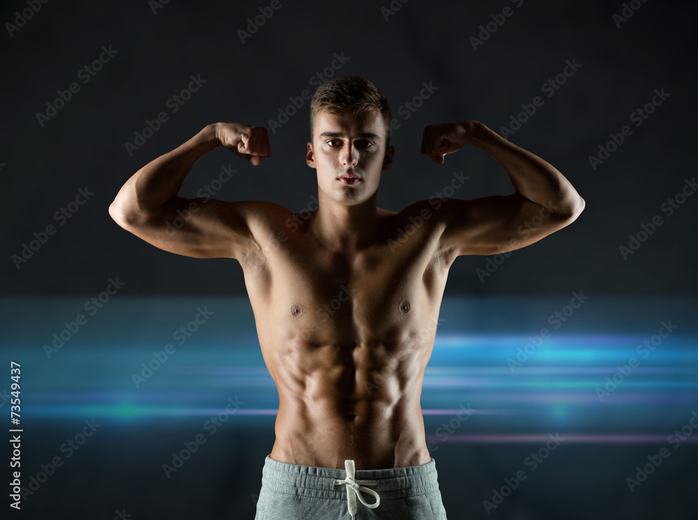 Fototapeta premium young man showing biceps and muscles