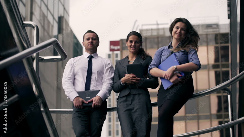 Happy businesspeople standing and looking to the camera Happy businesspeople standing and looking to the camera
