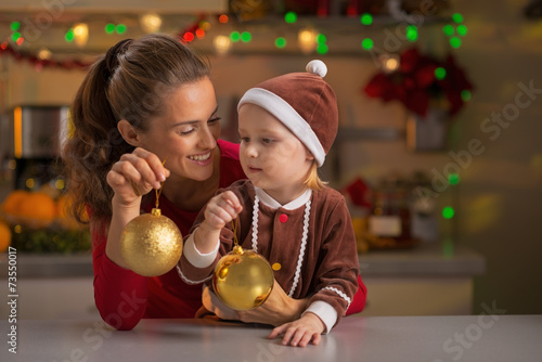 Portrait of mother and baby holding christmas balls