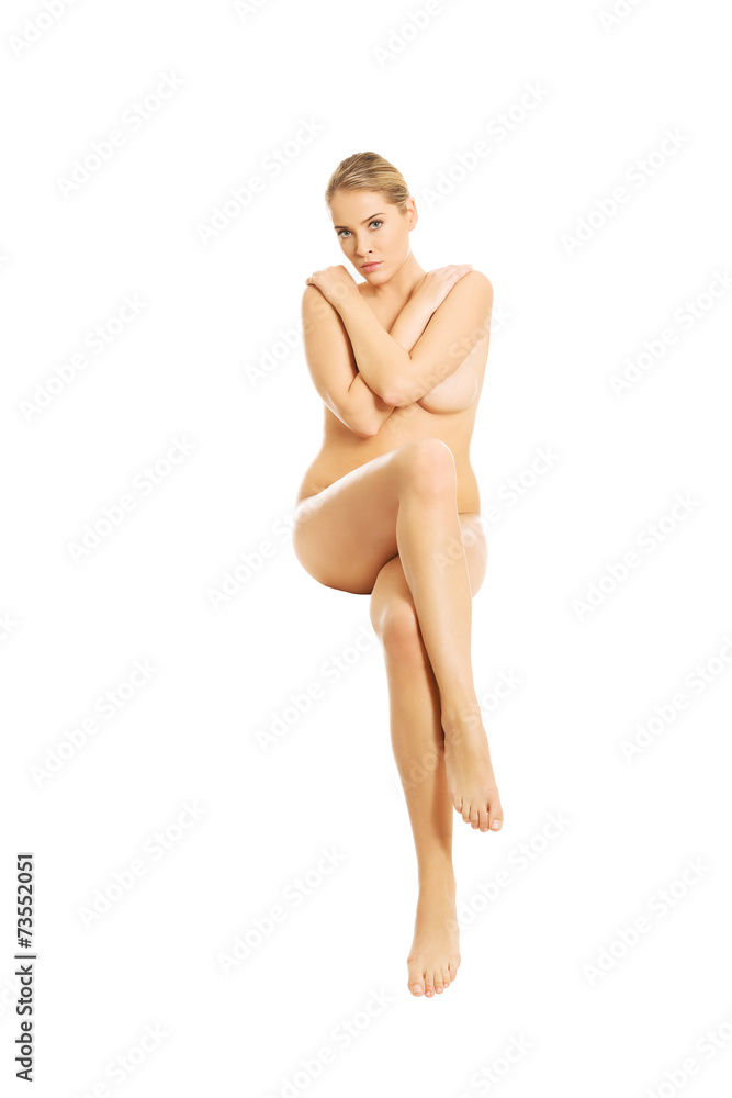 Fototapeta premium Full length nude woman sitting with crossed hands