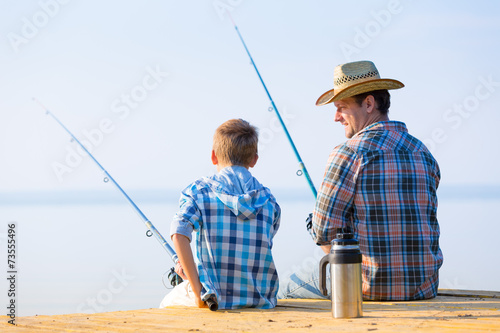 boy and his father fishing togethe