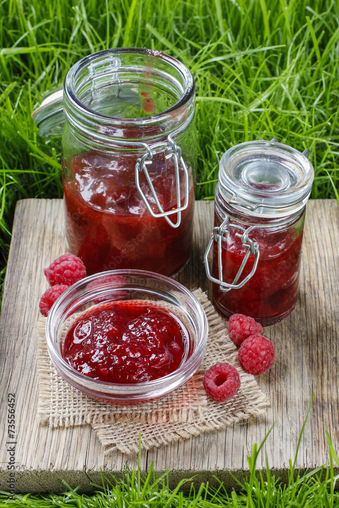 Raspberry jam on wooden tray in the garden Raspberry jam on wooden tray in the garden