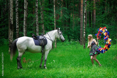 Girl and horse walking in the woods