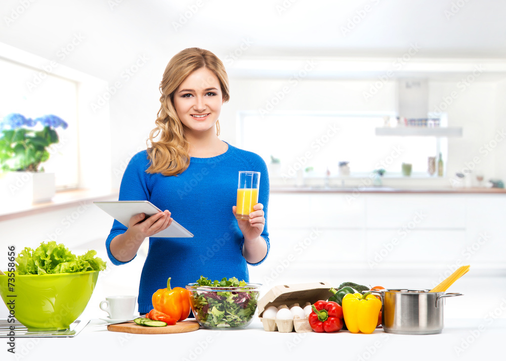 Young and beautiful housewife woman cooking in a kitchen Young and beautiful housewife woman cooking in a kitchen