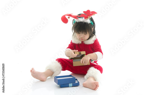 Cute asian baby wearing santa costume with present