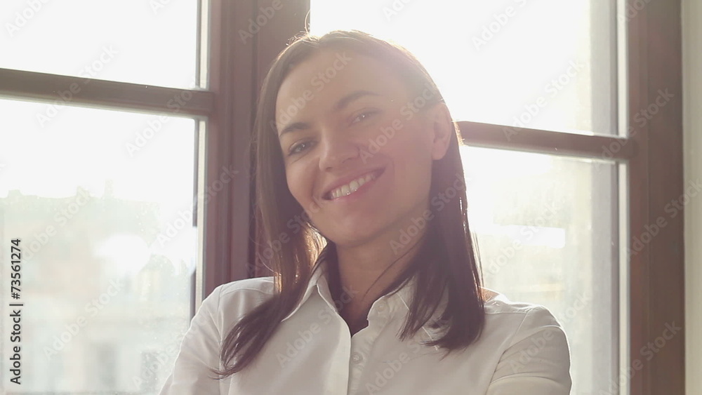 Happy smiling beautiful woman standing near window Happy smiling beautiful woman standing near window