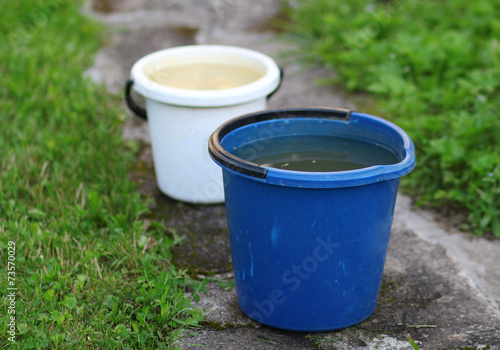 Two buckets standing on the road in the garden