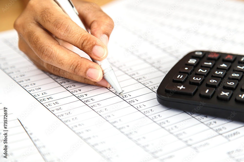 Close up woman hand holding pen on spreadsheet Close up woman hand holding pen on spreadsheet