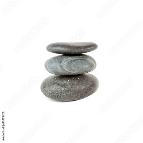 Three smooth stones on each other over white