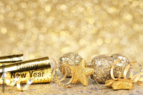 New Years Eve confetti and golden decorations on twinkling gold