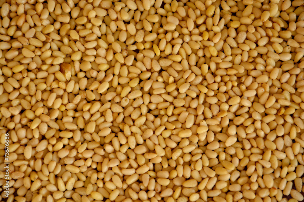 Nutty background made of peeled cedar pine nuts Nutty background made of peeled cedar pine nuts