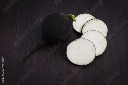 Черная редька на деревянном фоне, Black radish on a wooden backg
