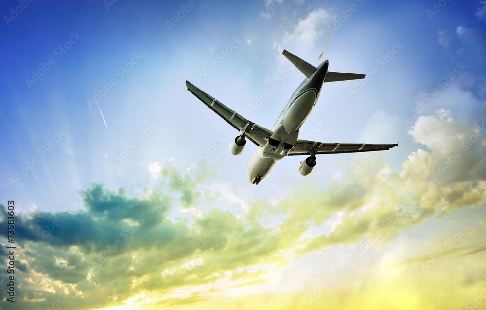 Obraz premium Airplane in the sky with dramatic sunset