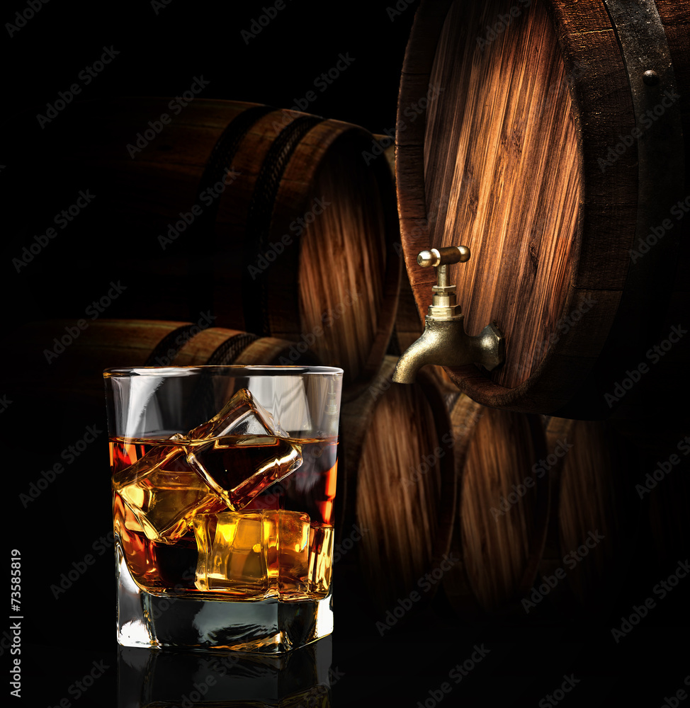 Glass of cognac on the vintage wooden barrel
